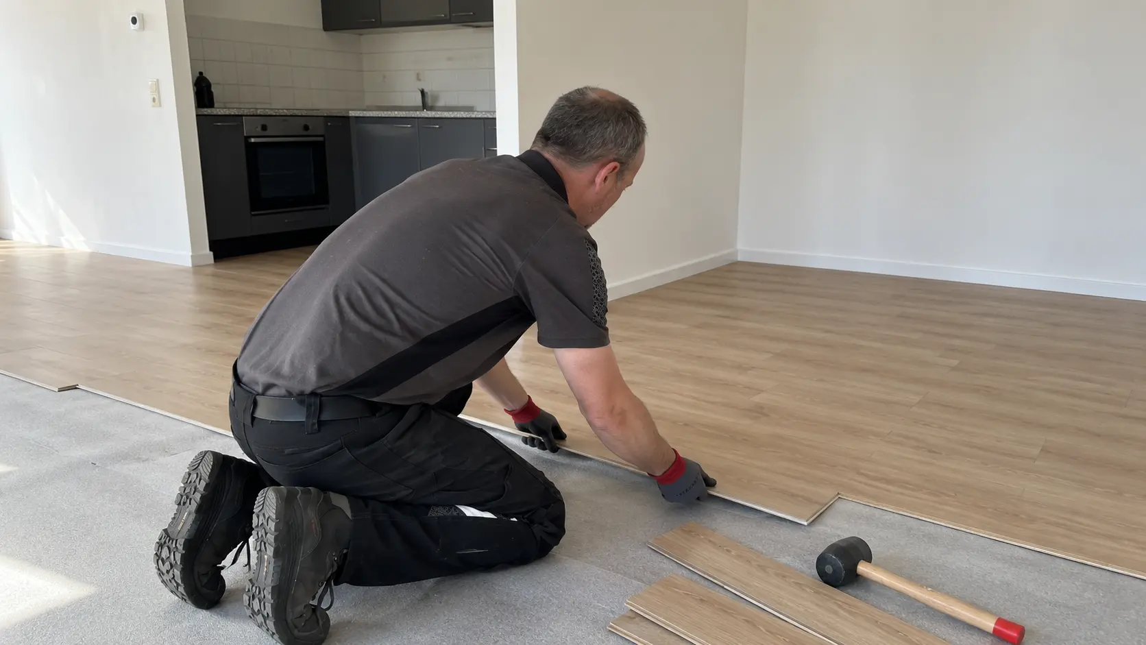 Marc van MT Kluswerk legt laminaat in een woonkamer