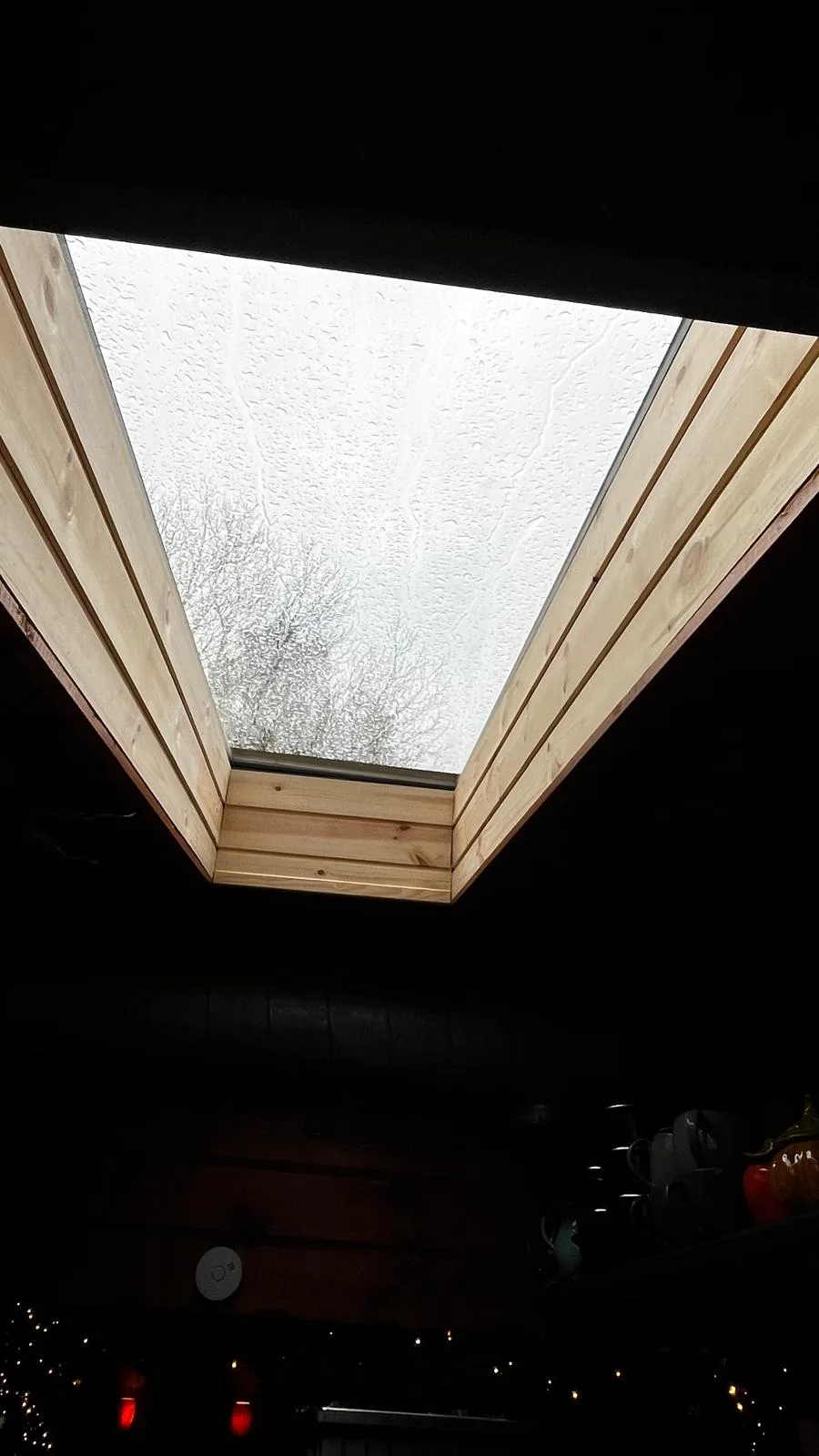 De aftimmering van het dakraam sluit aan op het houten plafond van het chalet