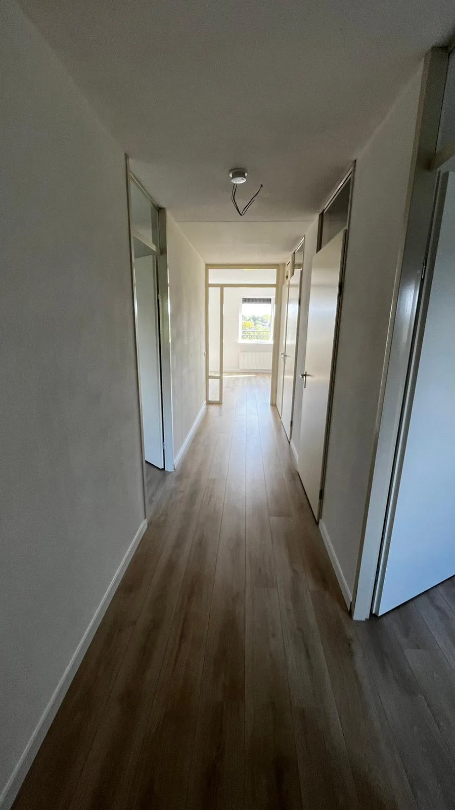 De hal met de nieuwe laminaatvloer, die in één lijn doorloopt tot in de kamers