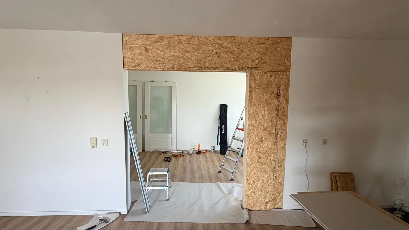 Stap 1: een houten frame met OSB-platen brengt de brede doorgang terug tot deurmaat
